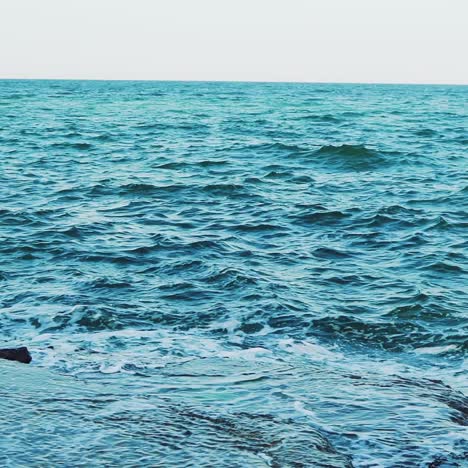 crests of the waves are breaking on the reefs near the shore in the summer. seascape. slow motion. aerial view