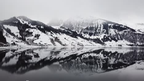 Maravilloso-Vuelo-De-Drones-Sobre-Un-Lago-De-Montaña-Reflectante-En-Suiza