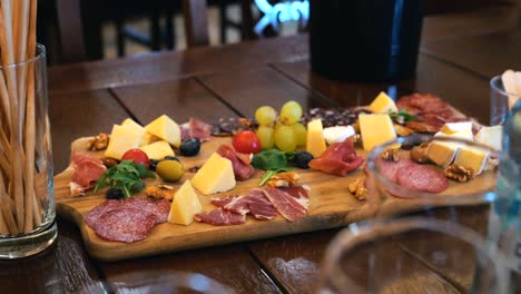 cheese plate with meat, nuts, fruits, and vegetables at a wine tasting event