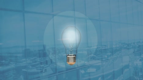 Animation-of-light-bulb-over-office-on-blue-background