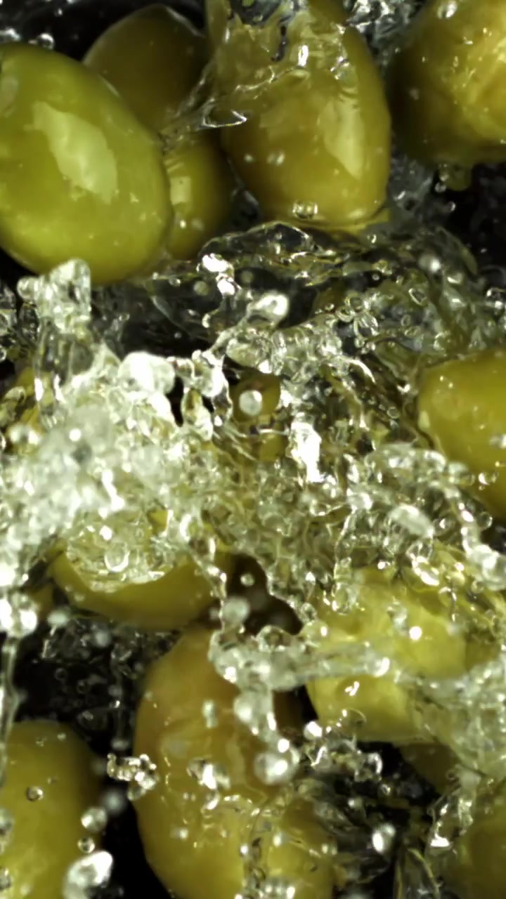 Schizzi d'acqua al rallentatore su olive verdi fresche