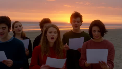 youth choir sings on a beach at sunset