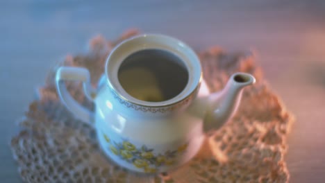 the man puts thyme tea in a teapot and fills with boiling water