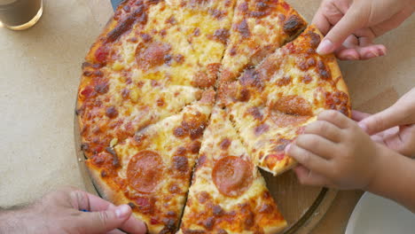 people taking slices of pizza