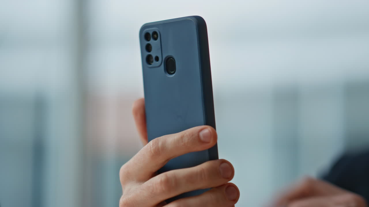 Entrepreneur hands tapping smartphone browsing application in office closeup