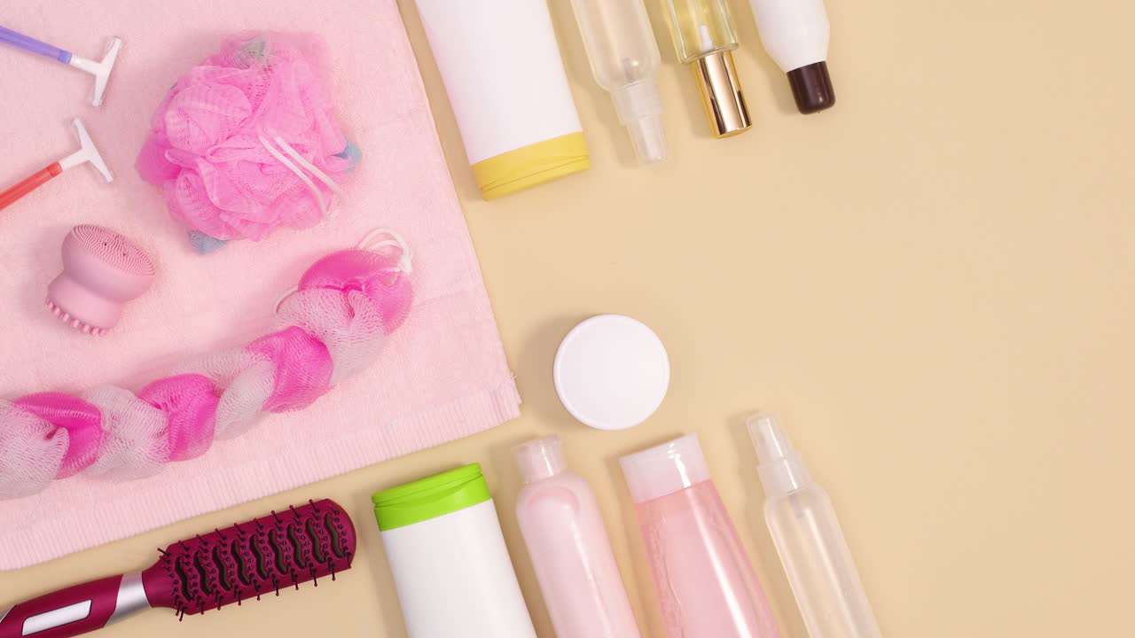 피부 관리 스파 제품은 분홍색 수건과 함께 베이지 바탕에 움직입니다.