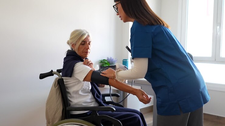 Nurse checking blood pressure of senior woman
