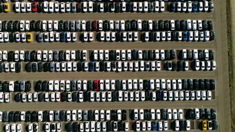 aerial footage of finished cars ready to be shipped on huge distribution center