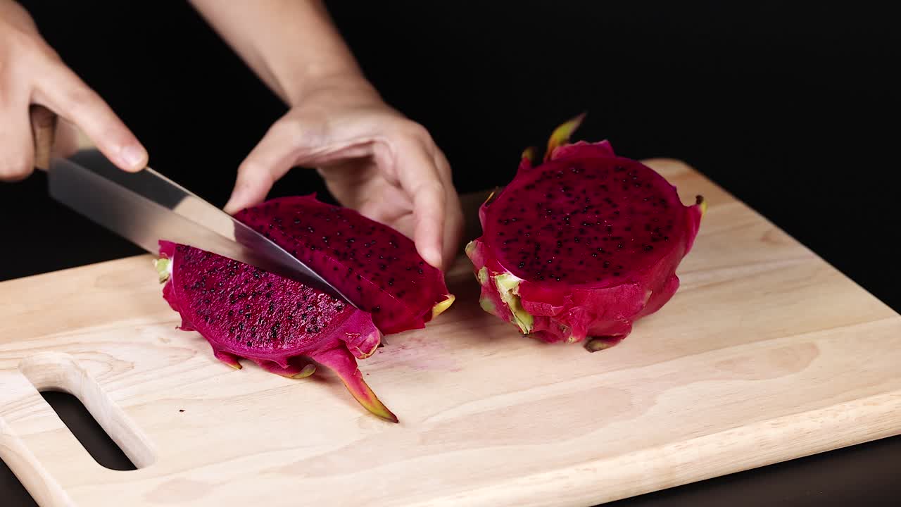 manos cortando la fruta del dragón con un cuchillo