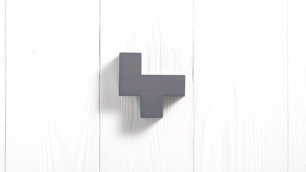 formas geométricas que cambian de color y forma sobre un fondo de madera blanca.