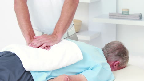 physiotherapist doing back massage to his patient