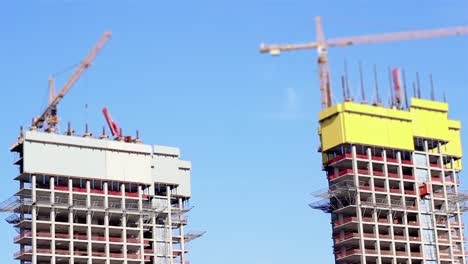 un edificio de la ciudad está siendo hecho por dos enormes grúas de construcción blancas 1