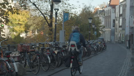 cyclist passing parked bicycles in old city center in the netherlands