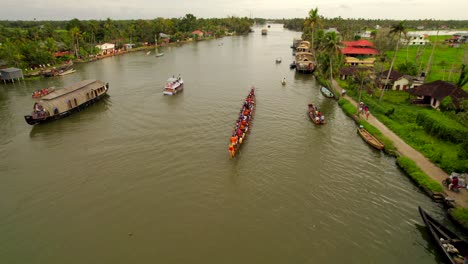 dozens of people in a long canoe training on kumarakom river for kerala national vallam kali racing competition