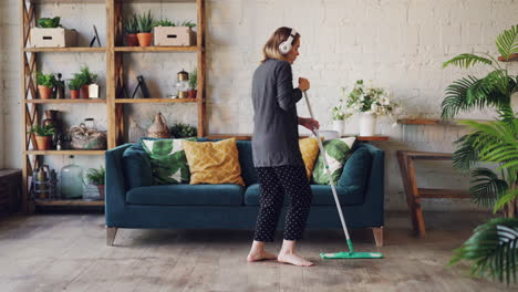 woman mopping and dancing in a living room