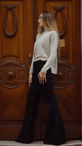 stylish woman in beige sweater and wide-leg jeans