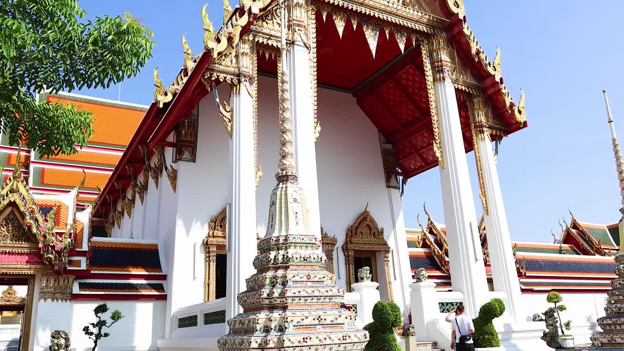 Turisti ammirano l'architettura ornata dei templi a Bangkok