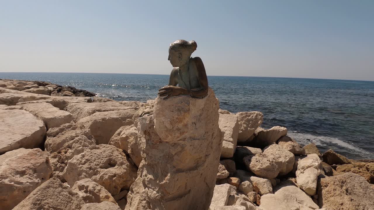 Sculpture “Sol Alter” by Yiota Ioannidou. This statue sits next to the Paphos Coastal path near Paphos Fort. Rocky coast and calm sea in the background, a sunny summer day in Cyrpus.