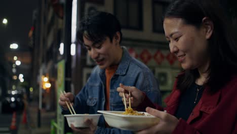 couple enjoying ramen on a night street in asia