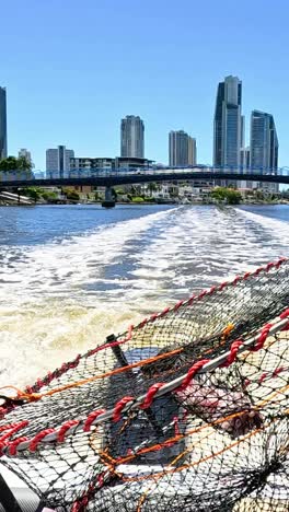 boat travels with crab pot near city skyline