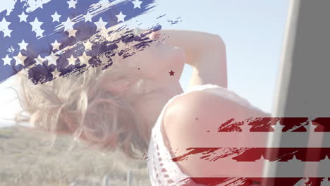 animation of flag of usa over happy caucasian woman in car by beach in summer