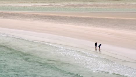 Una-Pareja-Juega-Con-Su-Perro-En-La-Playa-De-Luskentire