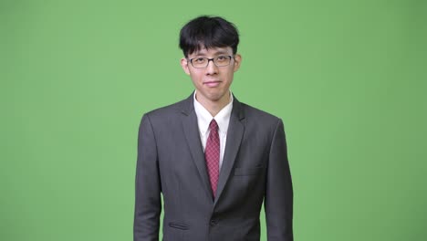 young happy asian businessman smiling while giving thumbs up