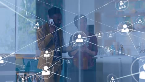 Animation-of-network-of-connections-with-icons-over-diverse-business-people-using-tablet