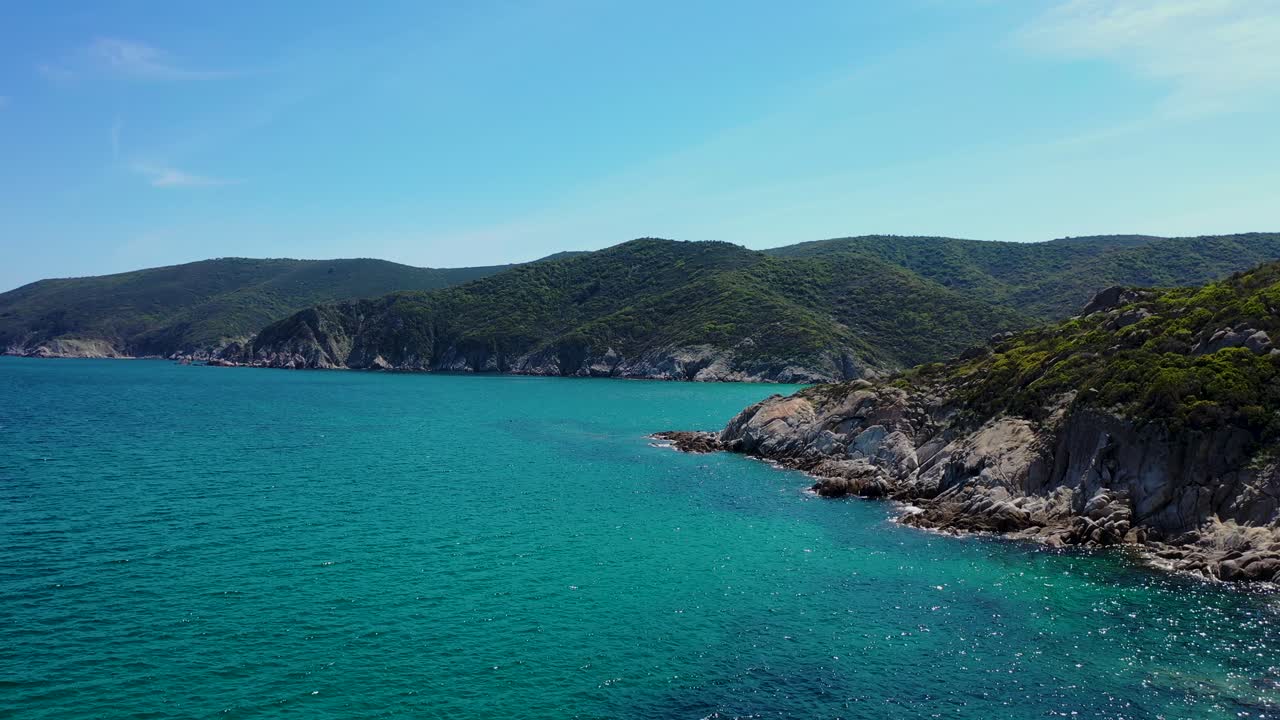 Spiaggia nascosta scoperta dietro la costa rocciosa e il mare blu cristallino nel Mediterraneo, riprese aeree.