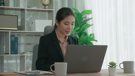 enthusiastic businesswoman working and typing laptop in the office.