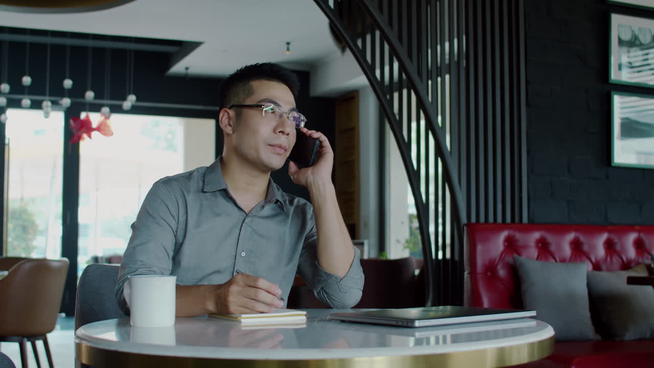 Analyst Consulting Clients on Smartphone Sitting at Desk