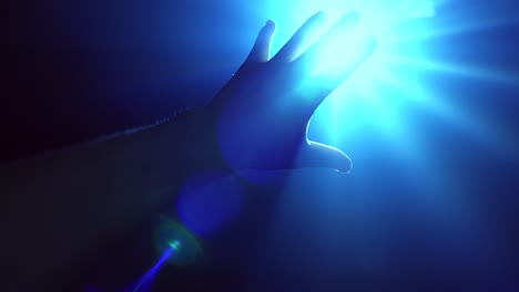 hand reaching out to cover shinning spot light