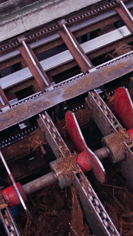 sawmill. process of removing bark from logs. special machinery with conveyor. heavy technic at plant, timber industry. view from the top. vertical video