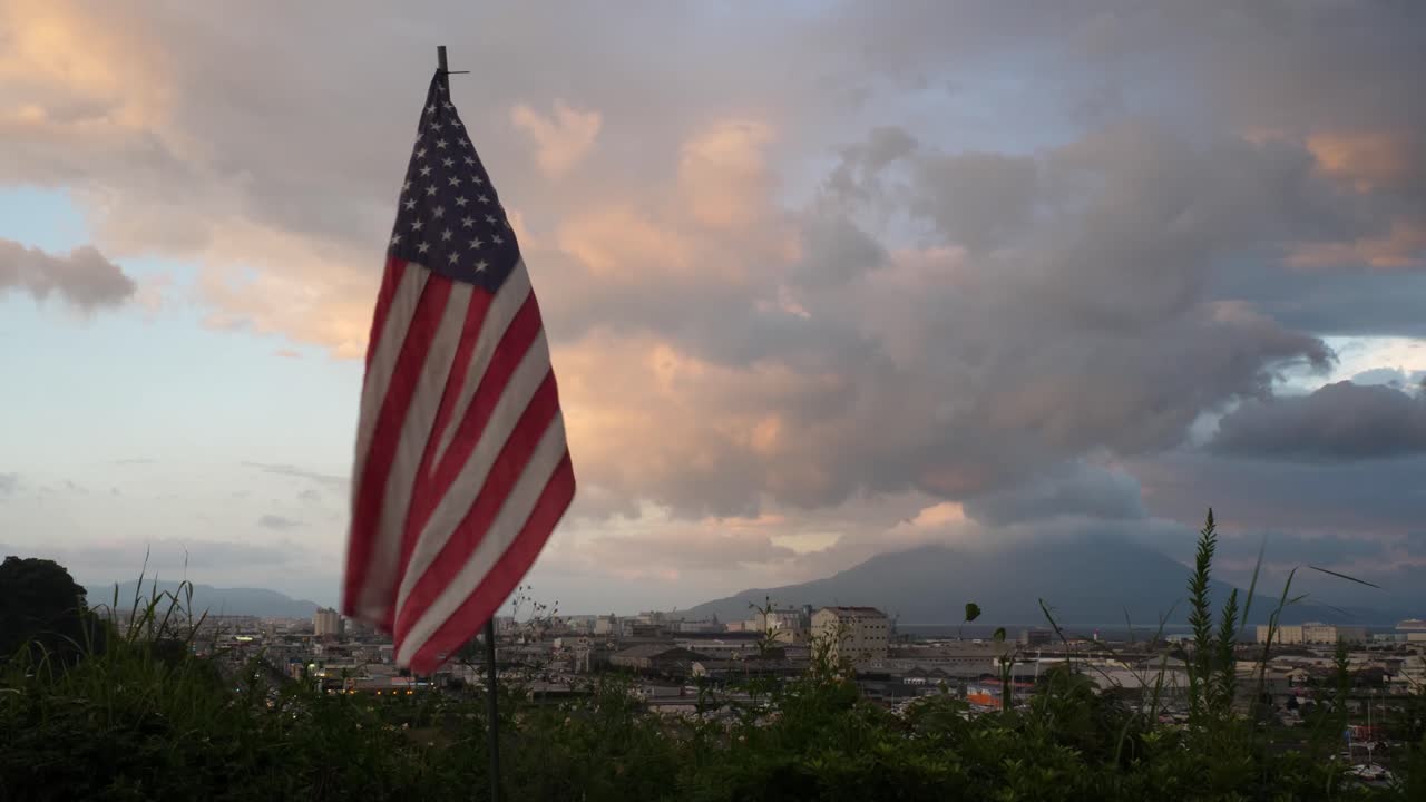Bandiera americana su una città giapponese al tramonto.