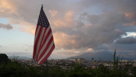 american flag over japanese city at sunset