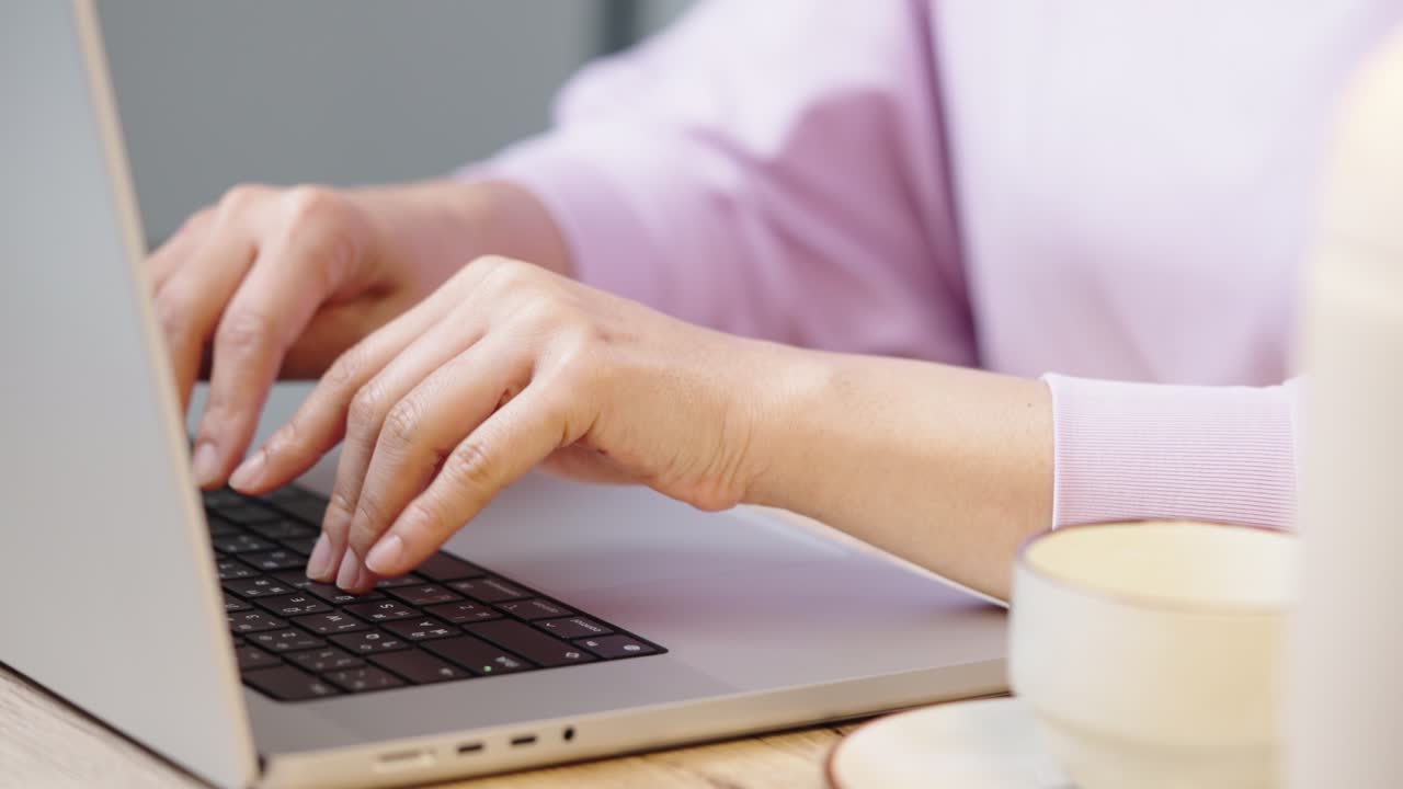 mano de cerca de una mujer de negocios escribiendo teclado computadora portátil en la oficina de escritorio