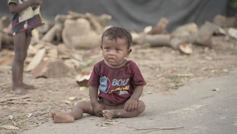 toddler boy sitting on dirt road