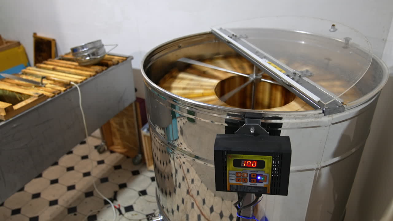Electric machine with metal carcass working indoors. Honey frames rotating in the apparatus to extract organic product.