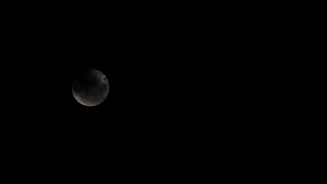 Ein-Vollmond-Mit-Einigen-Dunklen-Wolken,-Die-Vorbeiziehen