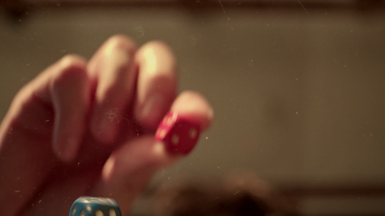 Dice in motion with a blurred hand