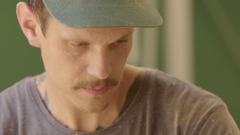 focused caucasian male woodworker carving out wooden log