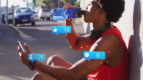 animation of media icons over african american man drinking water