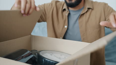 persona que está desempaquetando una caja de cartón