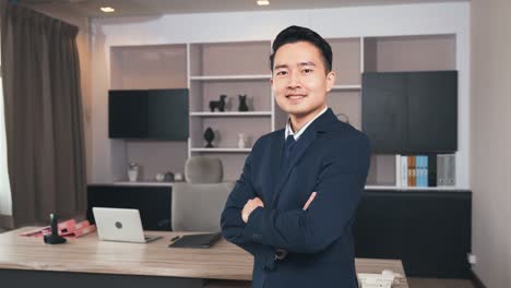 businessman leader smiling in formal suit glasses standing smart with his arms crossed in an office