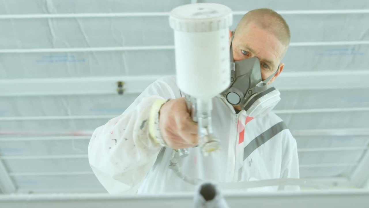 차고에서 전기 스프레이 총으로 자동차 부품을 칠하는 기계 4k