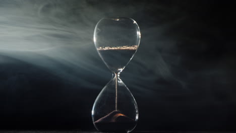 hourglass on a black background with mist swirling 1