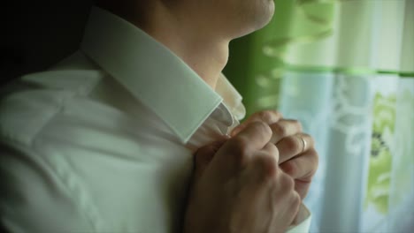 man getting ready in a white dress shirt