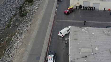 A-white-hearse,-with-two-police-vehicles-arrives-to-deliver-a-casket