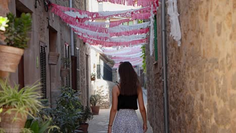 beautiful women going down a decorated sidewalk on a sunny day in valldemossa, highest village at mallorca