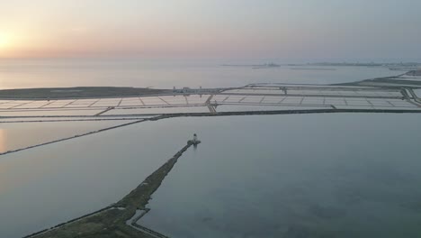 Trapani-Sicily-Italy-aerial-of-salt-pond-at-sunset-with-windmill-on-Mediterranean-Sea